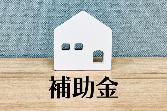 住宅補助金を表すミニチュアハウス