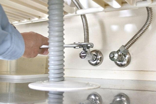 配管作業中のシンク下の修理